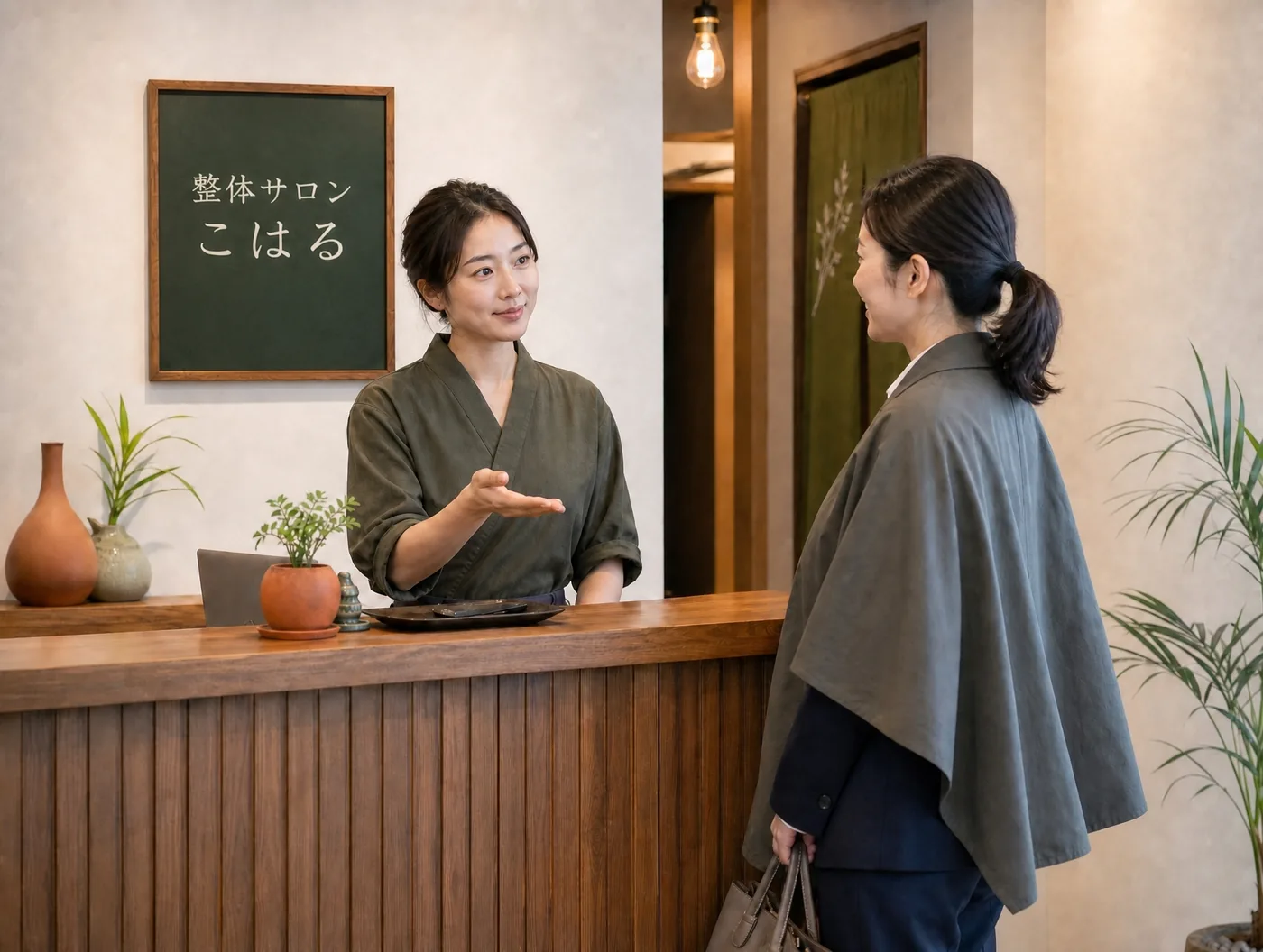 デモ用の生成画像(架空の受付風景)。ケープを羽織った利用客が受付でスタッフと話している。