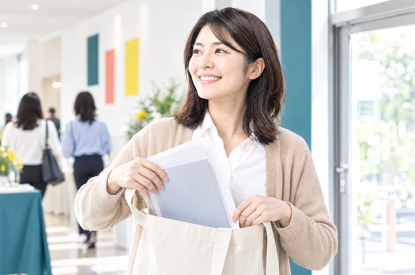 受講者が書き込んだシートを手提げ袋に入れて、笑顔で会場を出るところ