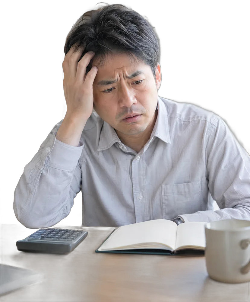 電卓とノートを前に頭を抱える男性