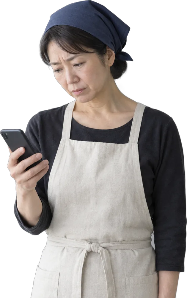 スマホを見て首をかしげる飲食店の店主